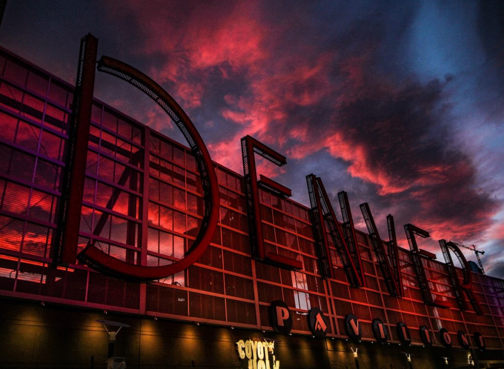 Close up of the Denver Pavilions sign with pink and blue clouds behind