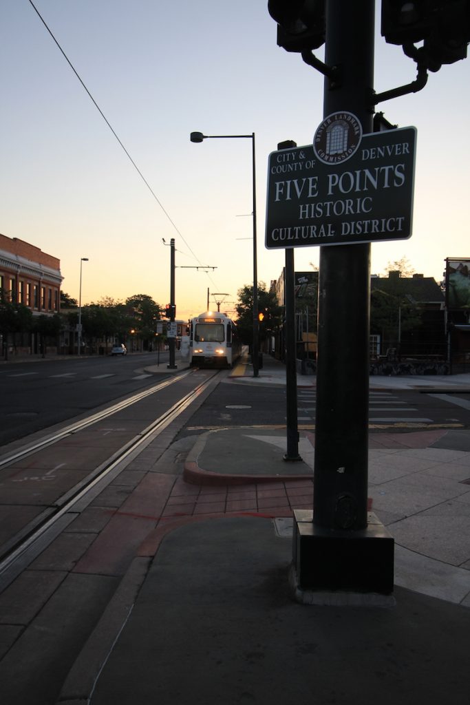 Five Points Historic Cultural District street sign with approaching light rail train in the background