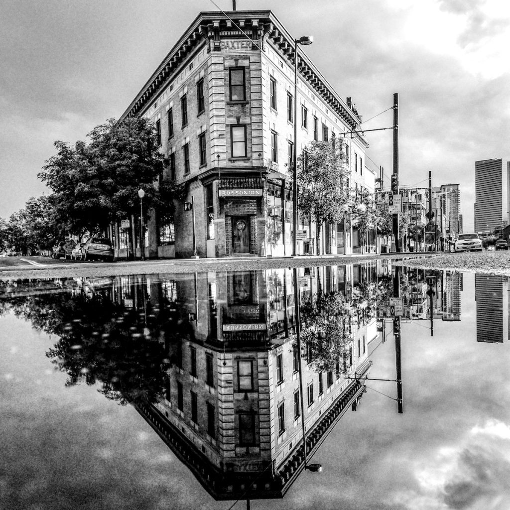 Black and white photo of the Rossonian Building with a pudle reflection