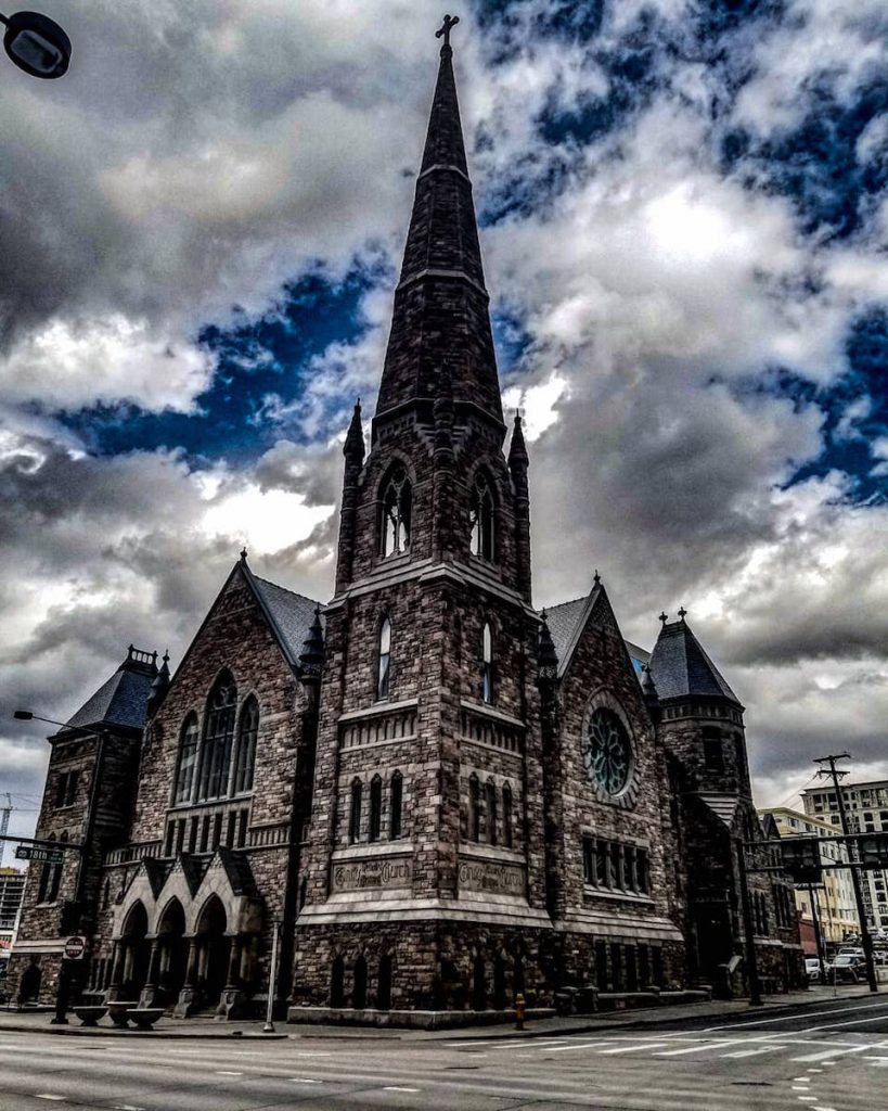 Trinity Methodist Episcopal Church exterior with intense clouds behind